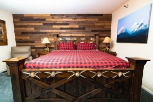 a bedroom with a large wooden bed with red pillows at Ski in out King bed Suite Mountain View in Kirkwood +9 photos