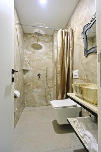 a bathroom with a sink and a toilet and a shower at Jera Rooms in Durrës