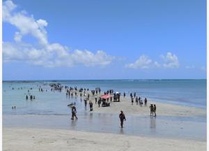 a group of people standing on a beach at Flats Raízes da Barra - Terceiro in Maragogi