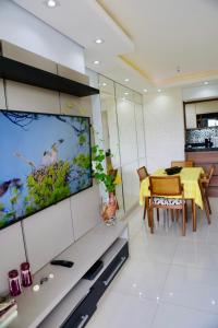 a living room with a tv and a dining room at Detalhes que te convida a aproveitar in Sorocaba