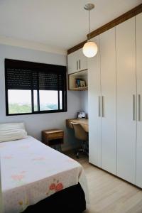 a bedroom with a bed and a desk and a window at Detalhes que te convida a aproveitar in Sorocaba +22 photos