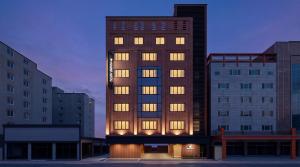 a tall building with many windows in a city at 통영 하운드호텔 죽림점 in Naejuk-to
