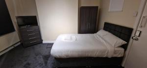 a small bedroom with a bed and a television at SELF CHECK-IN QUICK ROOMz WAKEFIELD in Wakefield