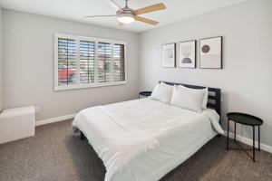 a white bedroom with a bed and a ceiling fan at Spacious Scottsdale Getaway with Pool in Tempe +52 photos