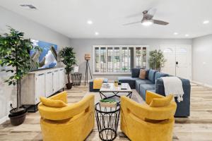 a living room with a blue couch and yellow chairs at Spacious Scottsdale Getaway with Pool in Tempe