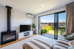 a living room with a fireplace and a tv at Flexible Bed Options, Private Back Yard, Car Park in Albert Town