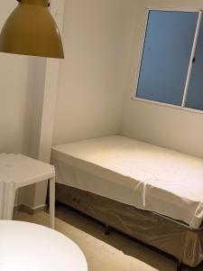 a small room with a bed and a window at Apartamento Estúdio in Macapá