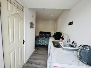 a kitchen with a sink and a bed in a room at Enjoy the comfort at private room en-suite with free Parking - near Luton airport in Luton