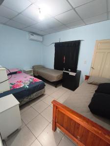 a room with two beds and a table in it at Jr hospedaje C in Paso de los Libres