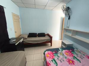 a room with a couch and a bed and a fan at Jr hospedaje C in Paso de los Libres