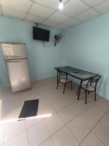 a kitchen with a table and a refrigerator in a room at Jr hospedaje C in Paso de los Libres