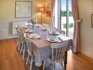 a dining room with a table with chairs and a tableclotholitics at Green Farm Cottage in Redgrave