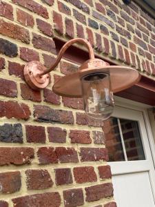 a light on the side of a brick building at Maison Lion Luxe gastenverblijf in Borgloon