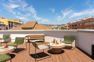 a patio with chairs and tables on a balcony at Serenay Málaga Hotel in Málaga