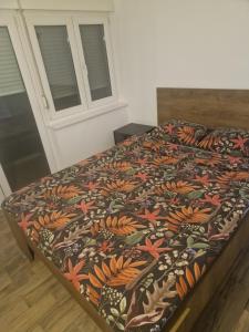 a bed with a colorful blanket on top of it at Centro apartman 3 in Pančevo
