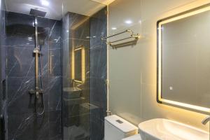 a bathroom with a shower and a toilet and a sink at Hotel Rodolfo in Tacloban +23 photos