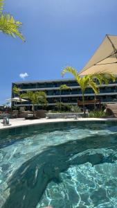 a large swimming pool in front of a building at Flat Lindo em Muro Alto Resort Beach Class Verano Porto de Galinhas in Porto De Galinhas