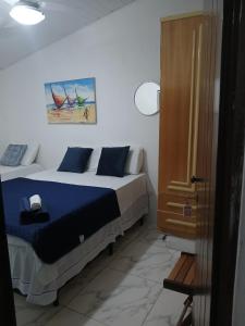 a bedroom with a bed with blue sheets and a cabinet at ElRancho Suites in Itaparica