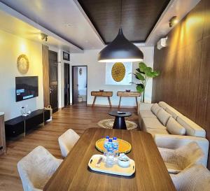 a living room with a table and a couch at Stana Puri Gopa Hotel in Sanur