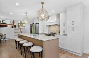 a kitchen with white cabinets and a large island with stools at Renovated Retreat with Heated Pool in Redding