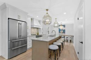 a kitchen with white cabinets and a island with bar stools at Renovated Retreat with Heated Pool in Redding +44 photos