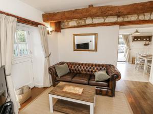 a living room with a leather couch and a table at Sheepwash Barn in Freshwater