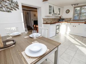 a kitchen with a table with white plates on it at Sheepwash Barn in Freshwater