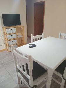 a white table and chairs in a room with a television at Vientos de Olavarria -Alquiler temporal in Olavarría