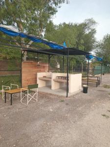 a picnic shelter with a ping pong table and benches at Vientos de Olavarria -Alquiler temporal in Olavarría