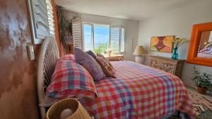 a bedroom with a bed with a checkered blanket at Bajo el Sol in Nelson