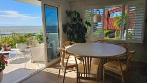 a dining room with a table and chairs on a balcony at Bajo el Sol in Nelson