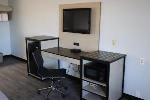 a room with a desk with a computer and a tv at legacy inn paducah in Paducah