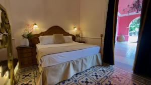 a bedroom with a bed and a door to a courtyard at La Casa Rosa Imperial in Mérida