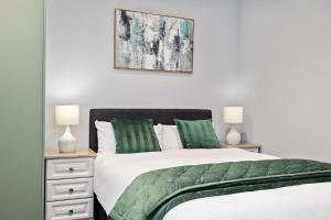 a bedroom with a large bed with green pillows at South Dublin Studio Apartment in Dublin