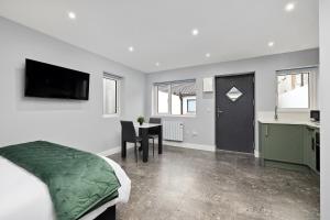 a bedroom with a bed and a table and a kitchen at South Dublin Studio Apartment in Dublin