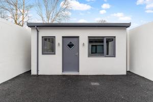 a white house with a door and a window at South Dublin Studio Apartment in Dublin