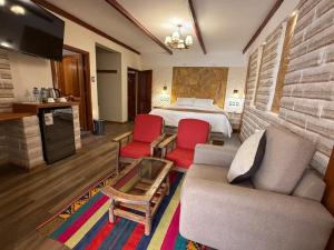 a hotel room with a bed and two red chairs at Hotel de Sal Atipax in Uyuni