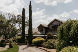 a house with cypress trees in the front yard at The George at Yering in Yering