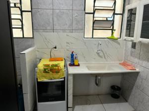 a white bathroom with a sink and a mirror at Proximo ao Shopping e Aeroporto 2 Quartos com Ar e TV a Cabo in Várzea Grande