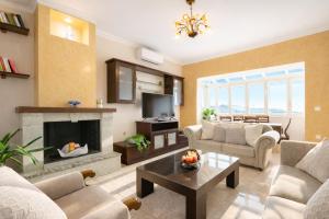 a living room with a couch and a fireplace at Villa Nirvana - Sea View Maisonette in Roda, Offering Tranquility and Comfort on the Enchanting Northern Coast of Corfu in (( Litherés ))
