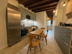 a kitchen with a wooden table and a stainless steel refrigerator at Appartement centre Toulouse Capitole in Toulouse +13 photos