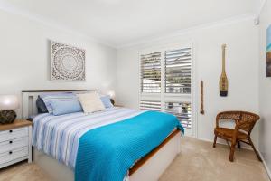 a bedroom with a bed and a chair and a window at Serenity - Pet Friendly with Spa & Waterfront in Sanctuary Point