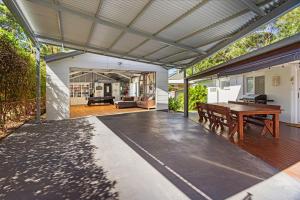 an outdoor entertaining area with a wooden table and a patio at Serenity - Pet Friendly with Spa & Waterfront in Sanctuary Point
