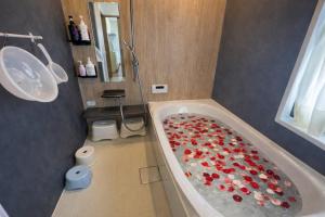 a bathroom with a tub with red flowers in it at Japan Family & Kids Castle Hotel Tokyo in Kisarazu +12 photos