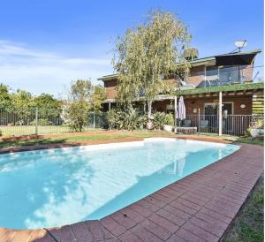 a swimming pool in front of a house at Cade Retreat in Yarrawonga