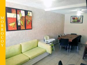 a living room with a couch and a dining room table at Casa en Ixtapa 3 recamaras con alberca in Ixtapa