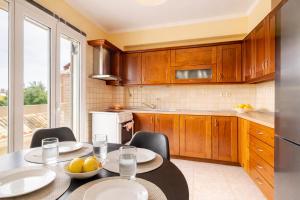 a kitchen with a table with two chairs and a kitchen with a window at Villa Nirvana - Sea View Maisonette in Roda, Offering Tranquility and Comfort on the Enchanting Northern Coast of Corfu in (( Litherés ))