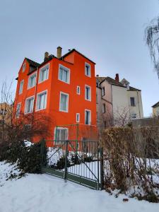 an orange building with a fence in the snow at 3 Apartments Angels o k b in Altenburg