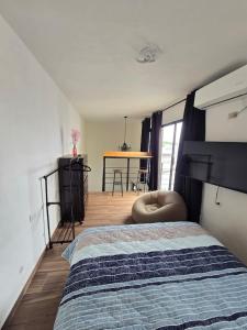 a bedroom with a bed and a table in it at Serenity Elegance Suite PB in Mérida +13 photos