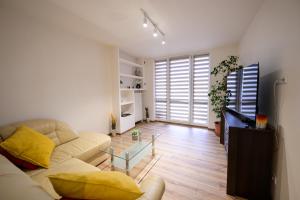 a living room with a couch and a glass table at Birdhouse Apartments in Prešov